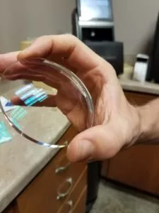 person holding eyeglass lens