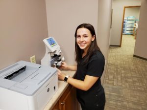 female employee working at optical testing machine